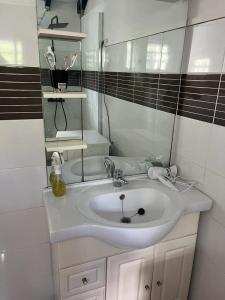 Baño blanco con lavabo y espejo en haut de villa spacieux et calme, en Morne-à-lʼEau