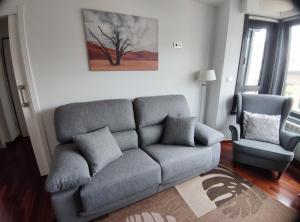 sala de estar con sofá y silla en Apartamento ANA - 1 Habitación en A Coruña