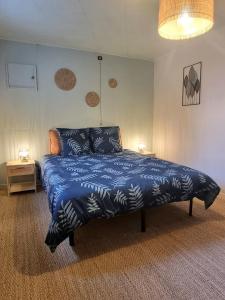 een slaapkamer met een bed met een blauw dekbed bij L'Expo in Hénin-Beaumont