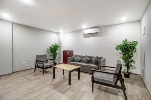a living room with a couch and a table and chairs at Super Townhouse RCC Majestic 397 LB Nagar in Hyderabad +59 photos