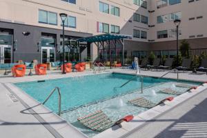 a large swimming pool with chairs and a building at Aloft Dallas Arlington South in Arlington