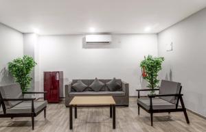 sala de estar con sofá y 2 sillas en Townhouse RCC Majestic LB Nagar, en Hyderabad