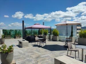 a patio with tables and umbrellas on a roof at Hotel San Francisco in Ubaté