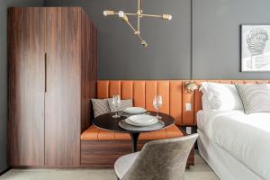 um quarto com uma mesa e uma cama e uma mesa e cadeiras em Iconyc Charlie Hotel São Paulo - Soft Opening em São Paulo