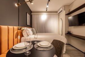 una habitación de hotel con una cama y una mesa con platos. en Iconyc Charlie Hotel São Paulo - Soft Opening, en São Paulo