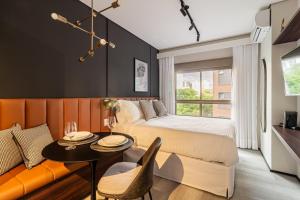 圣保罗Iconyc Charlie Ibirapuera Hotel的一间卧室，里面有一张床、一张桌子和一扇窗户