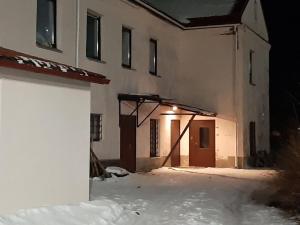 eine Außenseite eines Gebäudes mit Schnee auf dem Boden in der Unterkunft Rooms near the station in Narva