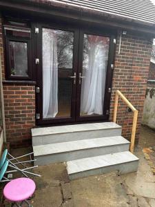 a front door of a brick house with stairs at The Hamilton Gated 2Bedroom Annex Dartford in Darenth