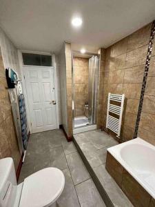 a bathroom with a toilet and a sink and a tub at The Hamilton Gated 2Bedroom Annex Dartford in Darenth
