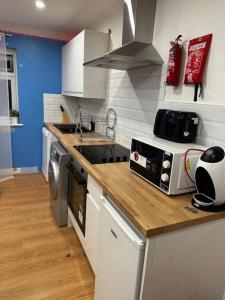 a kitchen with a counter with a sink and a microwave at The Hamilton Gated 2Bedroom Annex Dartford in Darenth