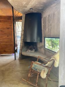 a rocking chair in a room with a fireplace at Casa Hector in Villa Elisa