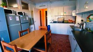 a kitchen with a wooden table and a refrigerator at Hostel Notro Valdivia in Valdivia