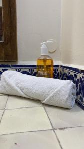 a towel and a bottle of soap on a bathroom floor at Posada Regional in Oaxaca City