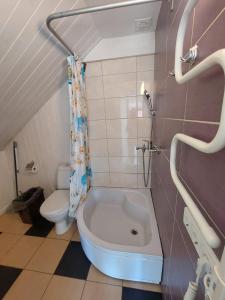 La salle de bains est pourvue d'une baignoire et de toilettes. dans l'établissement Plieņciems Urgas apartamenti 2. stāvā, à Plieņciems