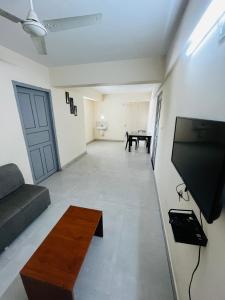 a living room with a couch and a flat screen tv at REGAL SUITES in Trivandrum +15 photos