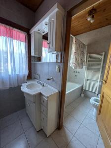 y baño con lavabo, bañera y aseo. en Casa 48 en El Calafate