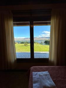 a bedroom with a window with a view of a field at Casa 48 in El Calafate