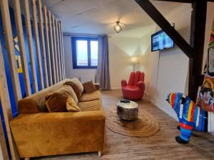 een woonkamer met een bank en een televisie bij L'Expo in Hénin-Beaumont