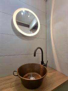 een koperen wastafel in een badkamer met een spiegel bij L'Expo in Hénin-Beaumont