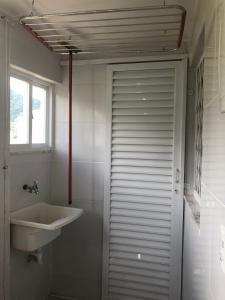 a bathroom with a sink and a white door at Casa para 4 pessoas RJ - Wiffi 500 mb in Rio de Janeiro