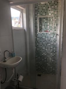 a bathroom with a sink and a shower with a glass at Casa para 4 pessoas RJ - Wiffi 500 mb in Rio de Janeiro