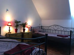 Dom Pracy Twórczej Muchomorek في Pieszyce: سريرين في غرفة نوم مع مصباحين ونباتات