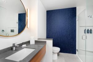 a bathroom with a sink and a toilet and a mirror at Fairfield by Marriott Luquillo Beach in Luquillo