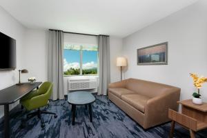 a living room with a couch and a table and a desk at Fairfield by Marriott Luquillo Beach in Luquillo