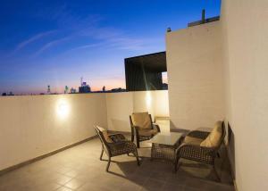 شقة انيقة وفاخرة بحي العليا Elegant and luxurious apartment Al-Olaya في الرياض: شرفة مع كرسيين وطاولة على مبنى