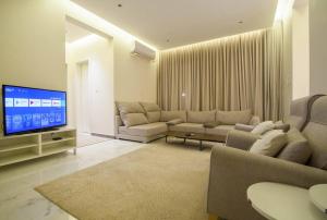 sala de estar con sofás y TV de pantalla plana. en شقة انيقة وفاخرة بحي العليا Elegant and luxurious apartment Al-Olaya en Riad