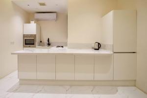 uma cozinha branca com um lavatório e um frigorífico em شقة انيقة وفاخرة بحي العليا Elegant and luxurious apartment Al-Olaya em Riade