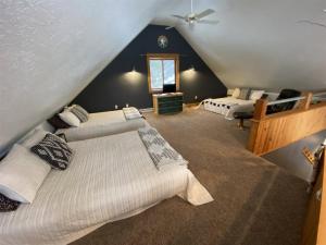 a attic bedroom with two beds and a window at Divided Sky in Lead