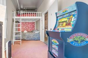 Cette chambre dispose d'un flipper et de lits superposés. dans l'établissement Chic 2-Bedroom Apt With Arcade, à Edmonton