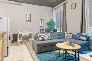 a living room with a blue couch and a table at Chic 2-Bedroom Apt With Arcade in Edmonton