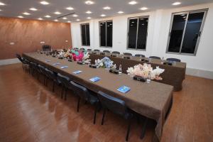 a long table in a room with chairs and flowers at Soulmate Hotel Erbil in Erbil