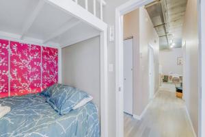 a bedroom with a bed and a red wall at Chic 2-Bedroom Apt With Arcade in Edmonton