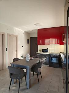 a kitchen with a table and chairs and red cabinets at Orchidea Flat in Tripoli