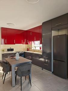 a kitchen with red cabinets and a table with chairs at Orchidea Flat in Tripoli