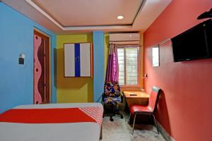 a bedroom with a bed and a desk and a television at Flagship Continental Stays Near Netaji Subhash Chandra Bose International Airport in Gauripur
