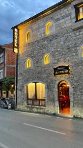 ein Steingebäude mit einem Schild für ein Restaurant in der Unterkunft Hotel - Kulla e Zenel Beut in Peja