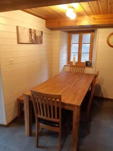 einen Holztisch und Stühle in einem Zimmer mit einem Tisch in der Unterkunft Charme et authenticité in Evolène