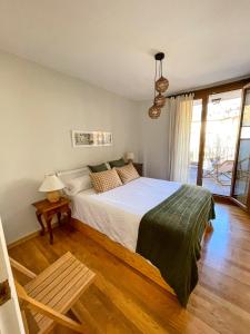 1 dormitorio con 1 cama grande y suelo de madera en Apartamento familiar en el centro de Benasque, en Benasque