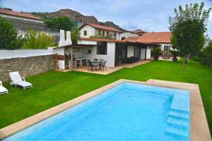 een tuin met een zwembad en een huis bij Casa vacacional Estudio 12 con encanto especial in Santander