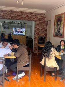 un grupo de personas sentadas en mesas en un restaurante en Cusco House Inn Hostel, en Cusco