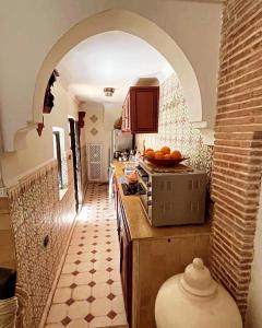 a kitchen with an archway and a counter with oranges on it at Riad Lalla Nora in Marrakesh