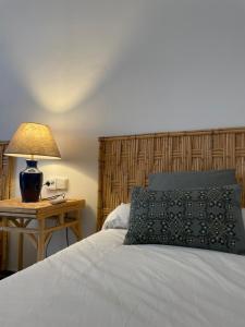a bedroom with a bed with a lamp on a table at Villa Marver in Algeciras