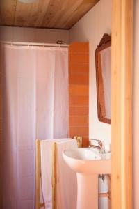 a bathroom with a white shower curtain and a sink at Aldeia das Cagarras in Santo Amaro