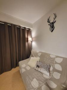 um quarto com uma cama com uma almofada e um relógio na parede em Appartement avec vue sur montagnes + garage em Font Romeu Odeillo Via