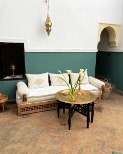 a living room with a couch and a table at Riad Lalla Nora in Marrakesh
