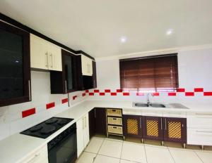 a kitchen with red and white tiles on the wall at Blue Haven in Mataffin